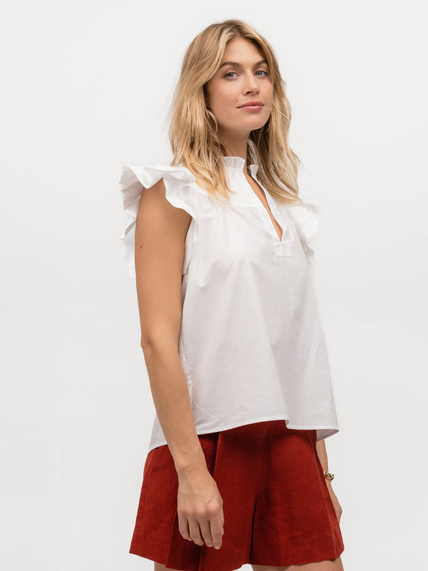 Woman wearing a white designer flutter sleeve shirt