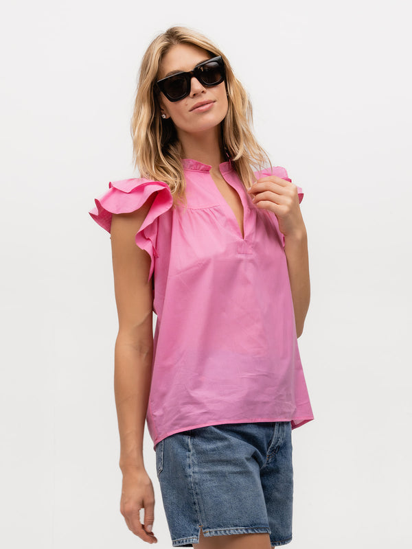 Woman wearing a luxury hot pink flutter sleeve shirt