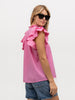 Lady wearing sunglasses and a ruffled designer shirt in hot pink cotton