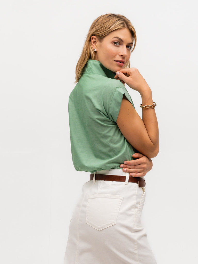 Woman showing back of a green luxury cap sleeve shirt