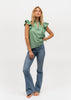Woman wearing jeans and a light green ruffle sleeve shirt