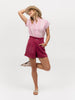 Woman playfully modeling a magenta and white cap sleeve top
