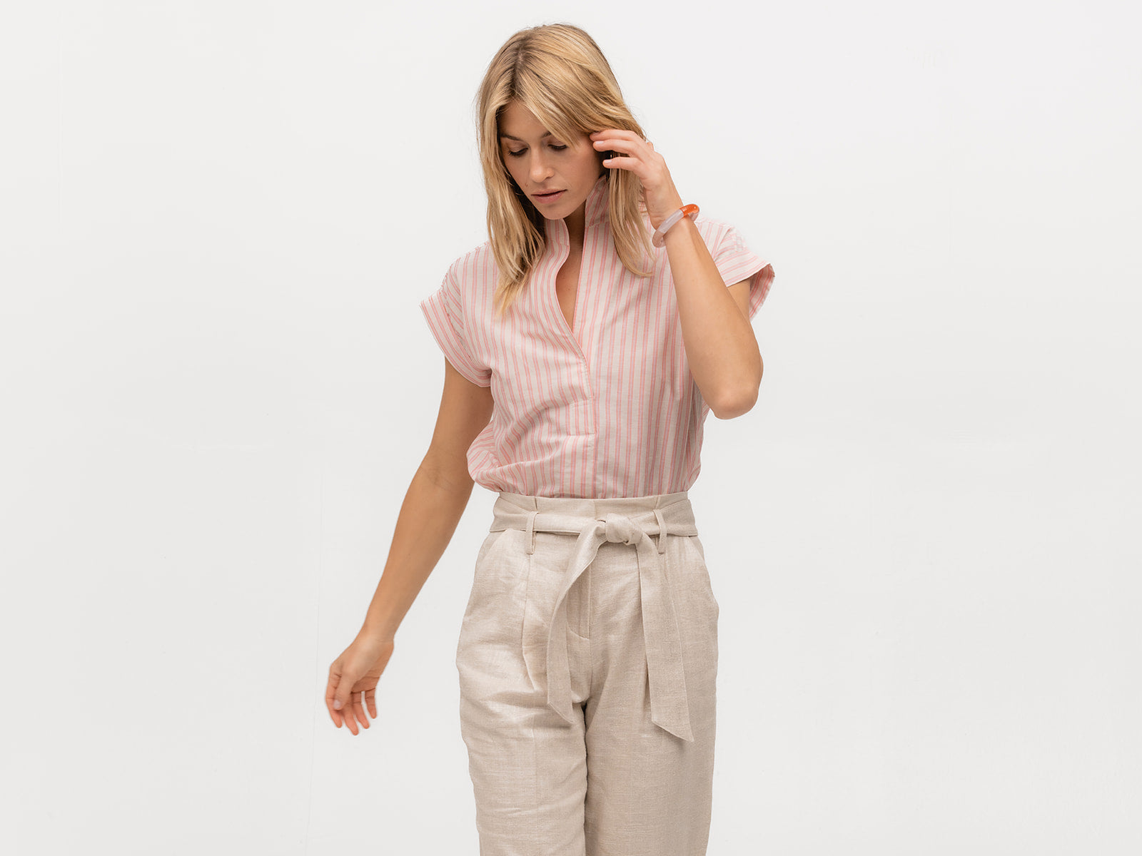 Model wearing an upscale short sleeve shirt with pink and shite vertical stripes