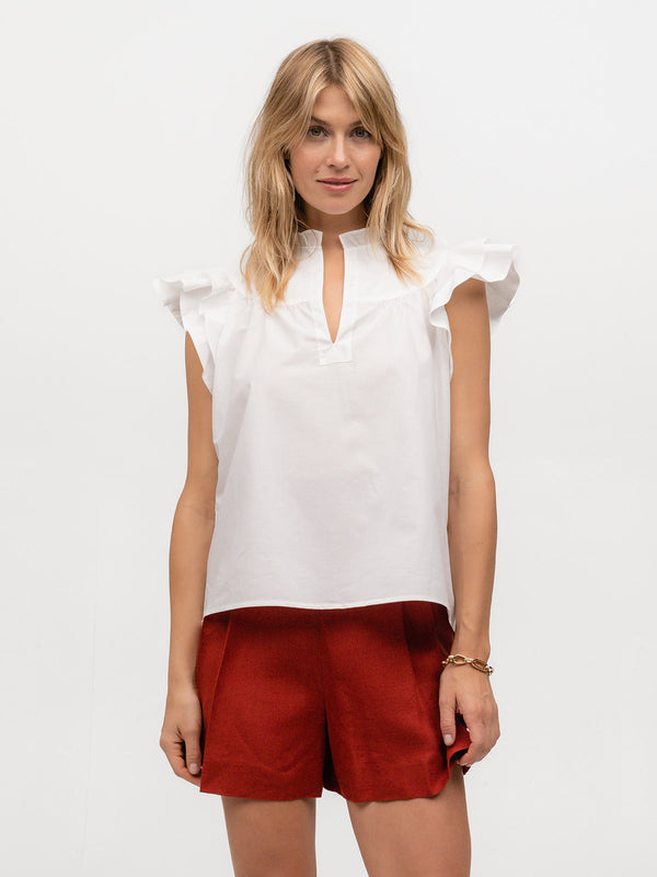 Beautiful woman wearing a flutter sleeve designer top made from white cotton linen