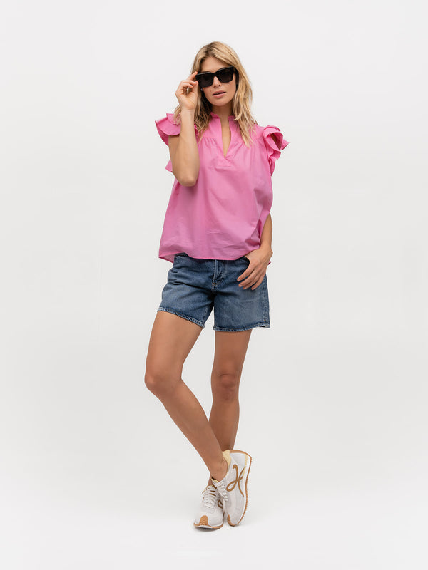 Fashionable woman wearing a hot pink designer shirt with ruffles