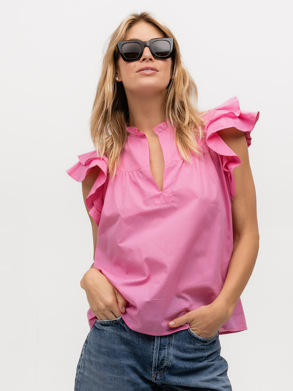 Woman wearing a bright pink ruffle sleeve top
