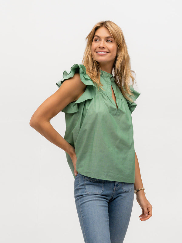 Pretty woman smiling in a flutter sleeve shirt in light green cotton