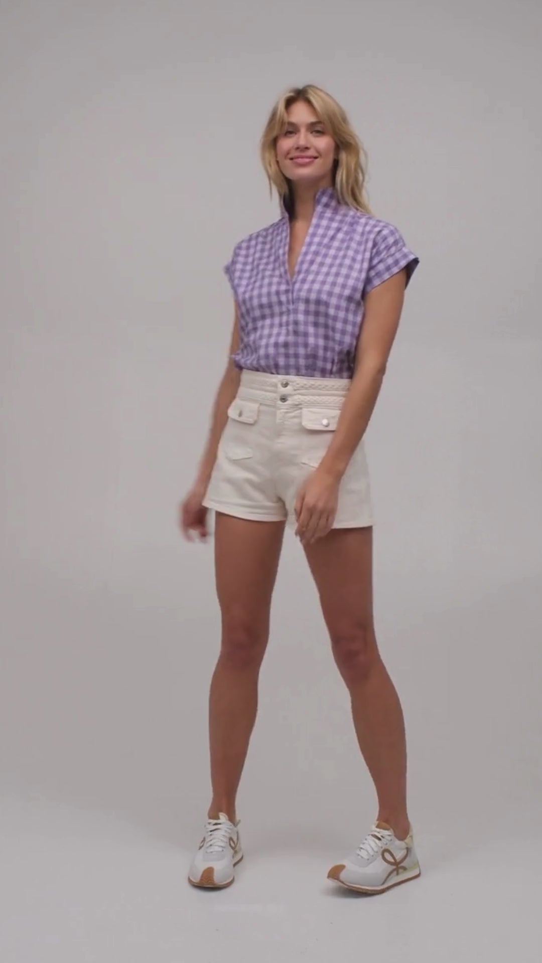 Pretty model wearing a purple gingham plaid cap sleeve designer top