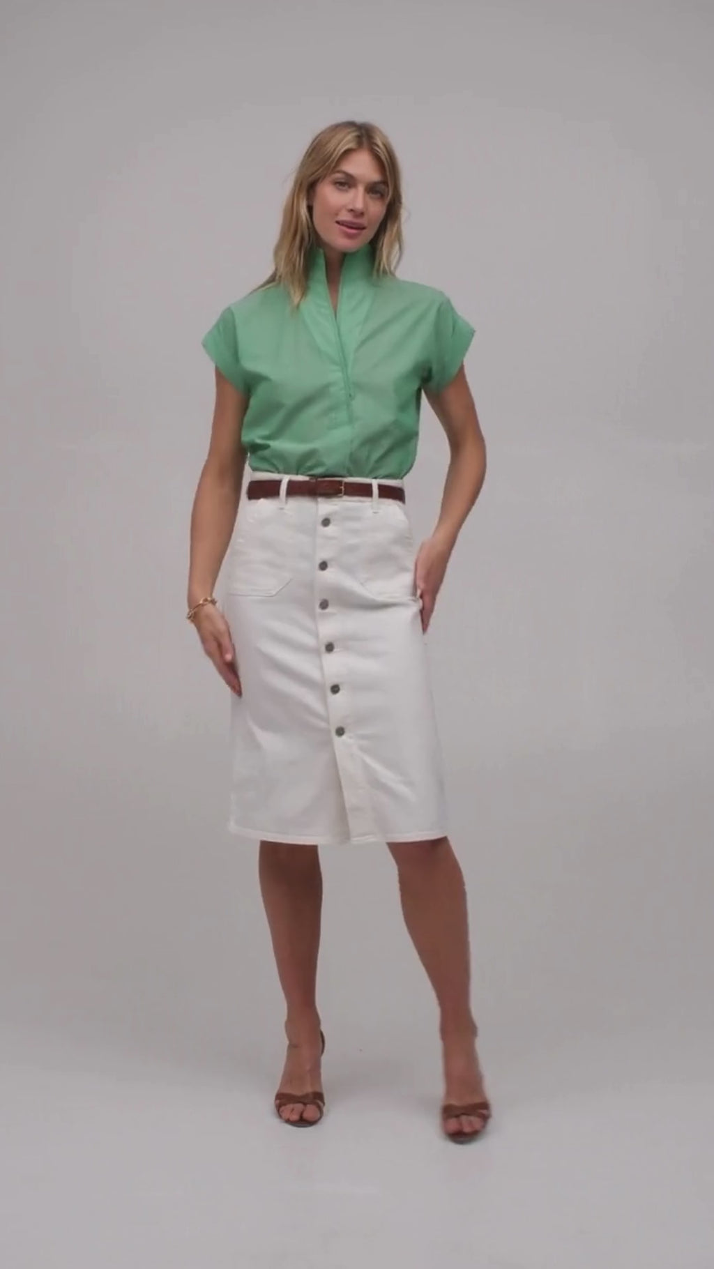 Woman modeling a light green short sleeve shirt by designer Sarah Alexandra