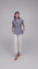 Woman modeling a designer cap sleeve top in light blue cotton chambray