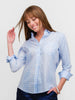Smiling woman wearing a pale blue polka dot button down shirt for women made of Italian 100% cotton.